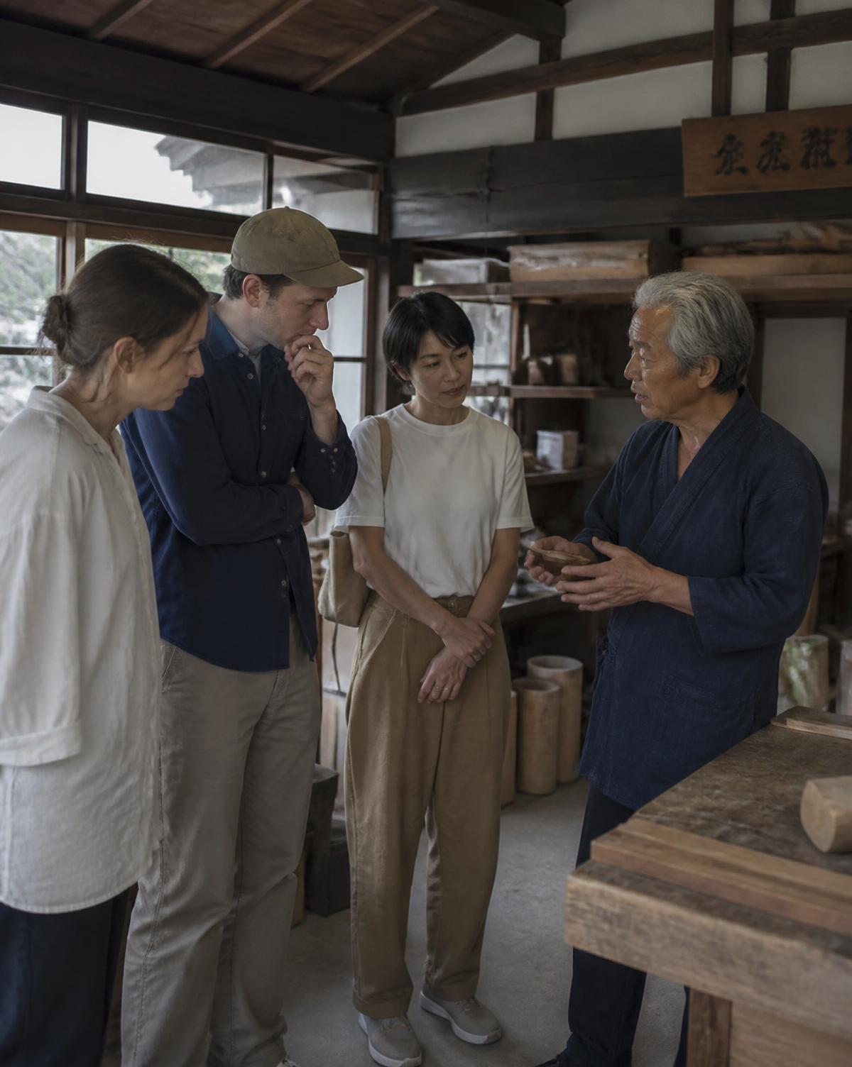 Members in conversation with a local craftsman in his workshop